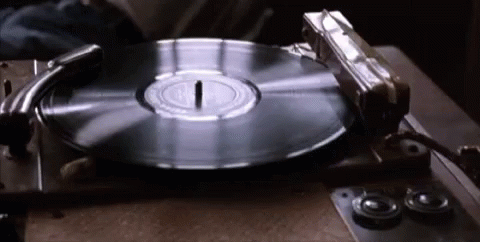 a turntable being placed on a table by a pair of hands