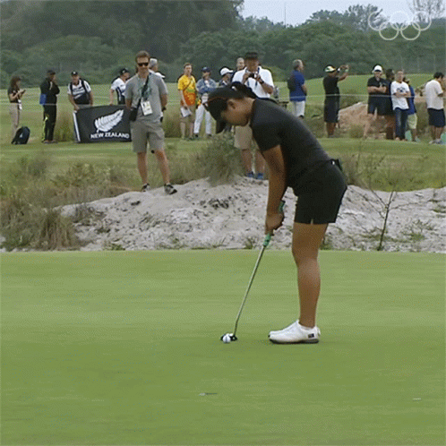 a girl is practicing her putter practice at the hole