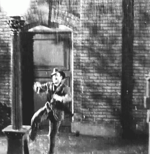 man leaning against a door with an umbrella over his head