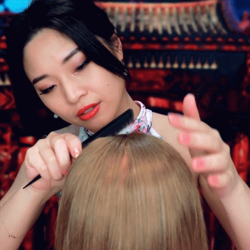 a woman is having her hair washed using a brush