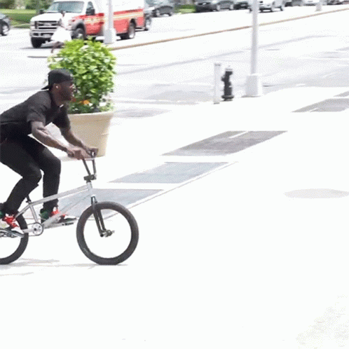 a man riding on a small bicycle with a black outfit