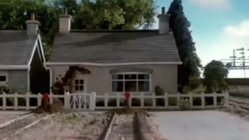 a train track running parallel to a house