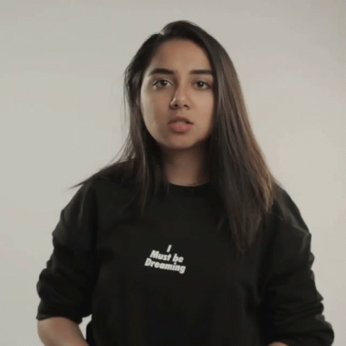 a girl that is wearing a sweatshirt with writing on it