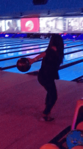 a woman holding a bowling ball in her right hand