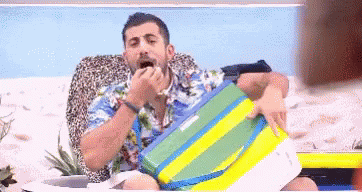 a man with his tongue out, eating while wearing a bathing suit