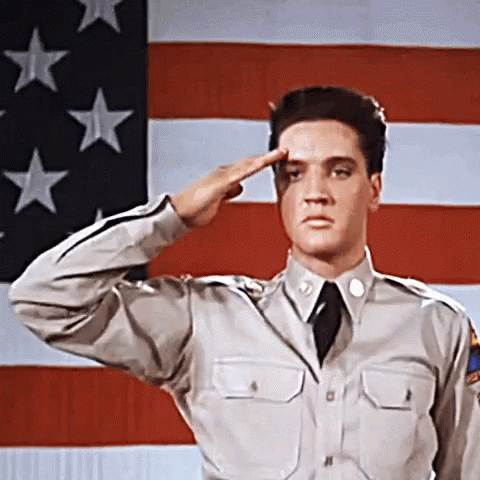 a man in uniform saluting with an american flag in the background