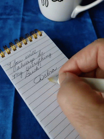 a hand holding a pen over a notepad