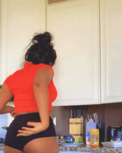 a woman in panties stands next to her kitchen counter