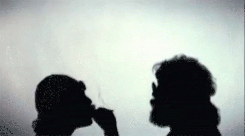 two people standing next to each other in silhouette
