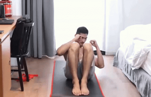 a man on a yoga mat holding his head with both hands