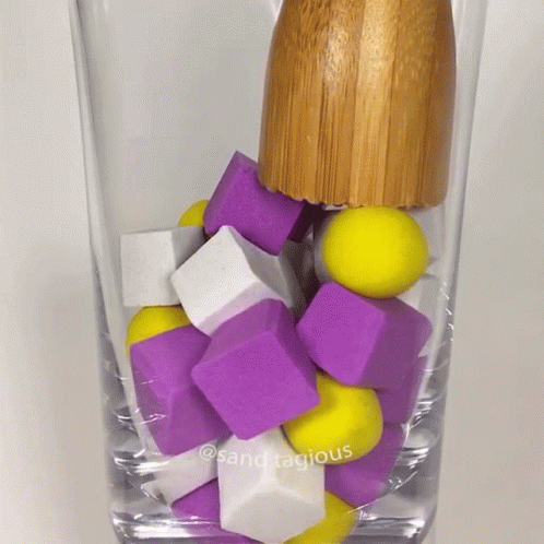 a glass filled with multi - colored squares and cubes