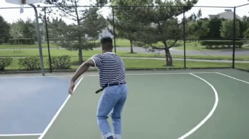 a man jumping into the air to hit a tennis ball