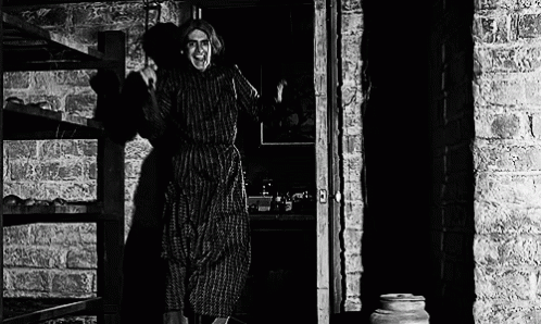 a woman walking out of a kitchen with a pot next to her
