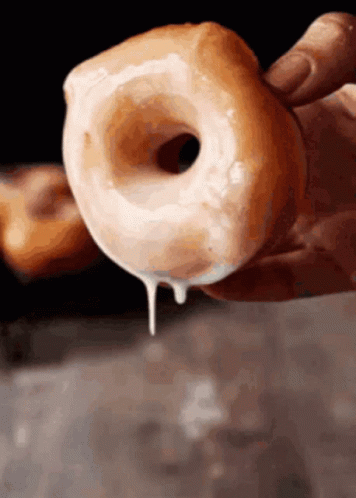 a donut dripping from a blue hand
