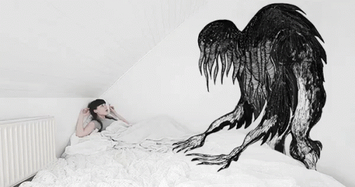 a person laying on top of a bed next to an enormous bird