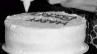 a person lighting the candle on a white cake