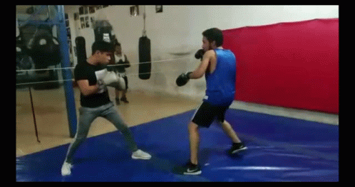 two people boxing while one looks on in the mirror