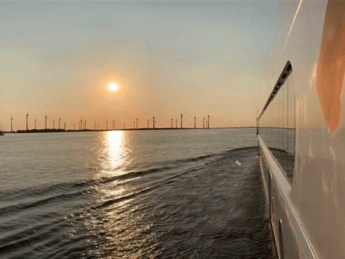 the view from a sailboat of an ocean and the sun