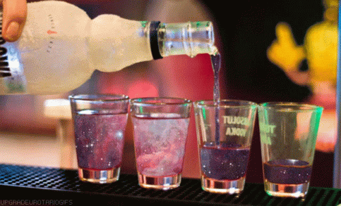 various glasses are filled with liquid at a bar