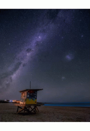 a lifeguard chair with a sky full of stars and galaxy in the background
