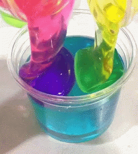 there are some liquids in a cup with colorful shapes