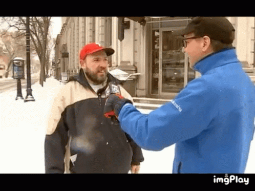 two men standing in the snow shaking hands