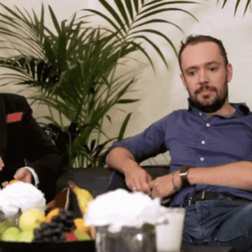 two men sitting next to each other on couches