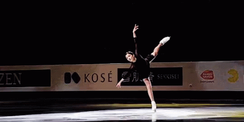 a female ice skater is performing on an ice rink