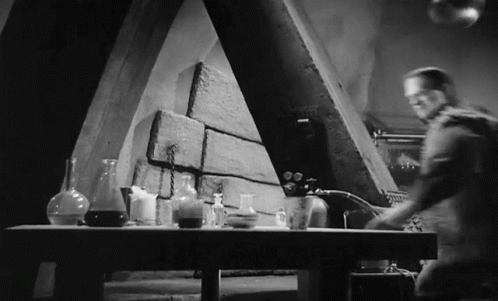 black and white pograph of a man in the kitchen with a bunch of items
