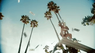 someone throwing paper in the air with palm trees nearby