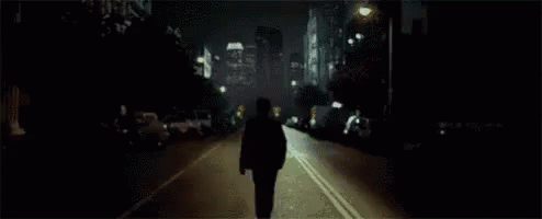 a person walking down the street in the dark at night