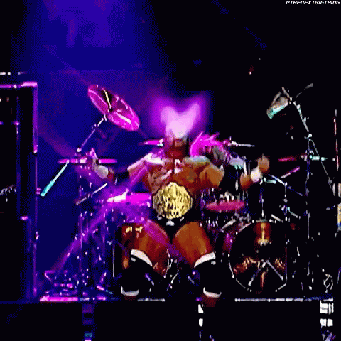 the man on stage is holding drums in his hands