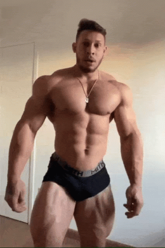 a bodybuilt man with  is standing and posing