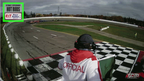 a person sitting on a bench watching a racing track