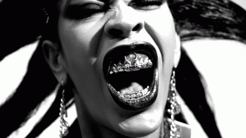 a woman with lots of teeth and piercings making her tongue out