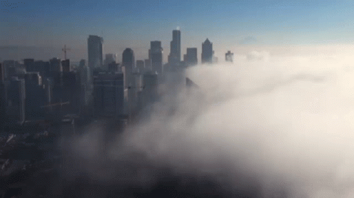 an aerial view of city on a foggy day