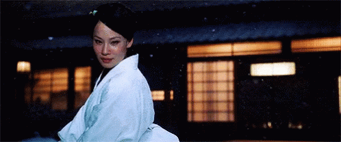 a woman in a white kimono walking outside