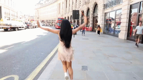a girl is dancing down the sidewalk in a very fuzzy outfit