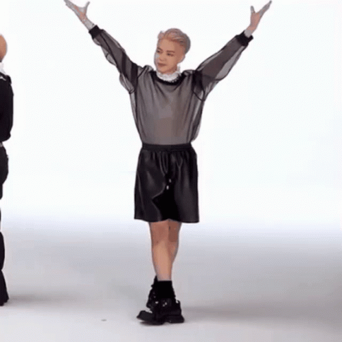 two male mannequins are standing together and one is holding his hands in the air