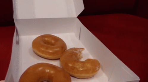 two blue donuts are in a cardboard box