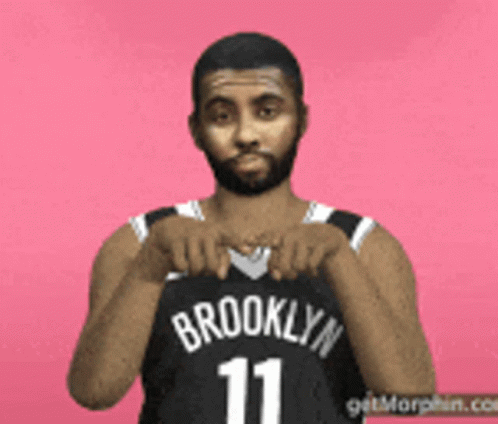 a man with a beard is holding a basketball jersey