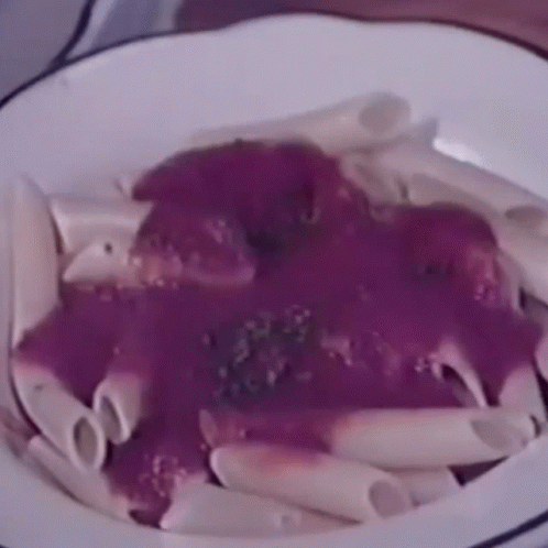 purple sauce over a dish of pasta in a white bowl