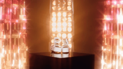 an illuminated pair of sneakers standing on top of a box