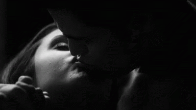 a man and a woman kissing in black and white