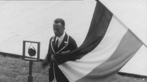 a man is standing in a field holding a large flag