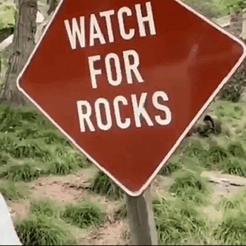 a blue sign that says watch for rocks