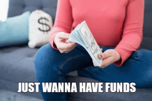 a person is sitting on a couch holding a bundle of money
