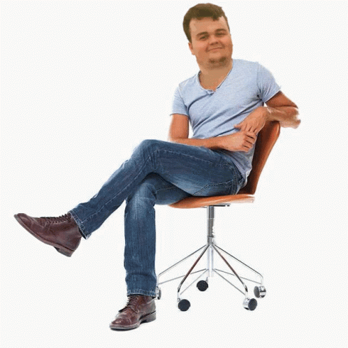 the man sits on top of a chair with his legs crossed