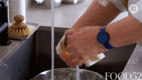 a person with blue gloves is washing some dishes
