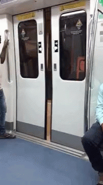 two men sitting on a subway car bench
